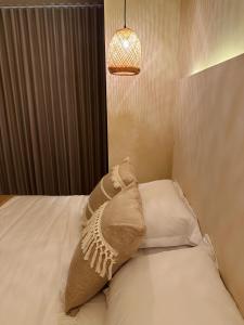 almohada sobre una cama con lámpara en Casa Gali, en Ríohacha