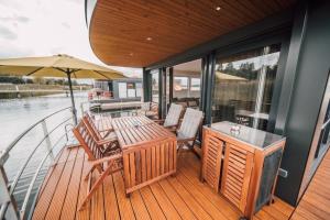 a deck with a table and chairs on a boat at Hausboot the Hideaway LP26 in Klitten