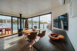 a dining room with a table and a view of the water at Hausboot Trinity - LP5 in Peenemünde