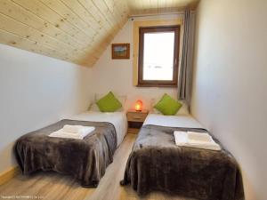 two beds in a room with a window at Domki Trzy Tatry in Ząb