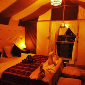 a bedroom with a bed with two stuffed animals on it at Bivouac Camel Trips in Merzouga