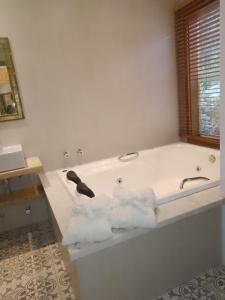 Una bañera blanca con tres toallas. en Afha 48 en Monte Verde