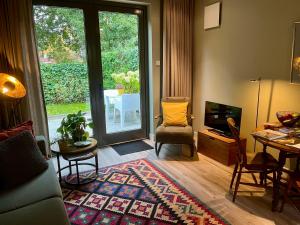 a living room with a couch and a television and a table at B&B In de Schulp, retreat into your shell in Amstelveen