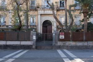 un edificio con una puerta marrón y una valla en B&B Palazzo Fischetti, en Catania