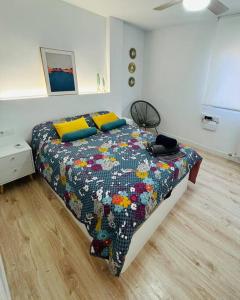 a bedroom with a bed with a colorful quilt on it at Nórdico -Apartamentos Birdie- in Albacete