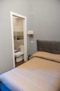 a bedroom with a bed and a bathroom with a toilet at B&B Palazzo Fischetti in Catania