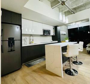 uma cozinha com um balcão branco e um frigorífico em New luxury and comfort apartment, fully furnished in Monterrey Centro. (Includes: Pool, Parking lot, A.C., WiFi, Gym) em Monterrey