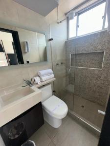 een badkamer met een wastafel, een toilet en een douche bij hermoso apt 201 corferias, embajada americana , agora , g12 in Bogota
