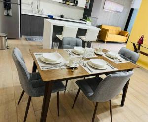 a dining room table with chairs and plates on it at New luxury and comfort apartment, fully furnished in Monterrey Centro. (Includes: Pool, Parking lot, A.C., WiFi, Gym) in Monterrey