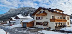 una casa en las montañas con nieve en el suelo en Haus Luise en Bad Hindelang