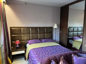 a bedroom with a large bed with purple sheets at Studio dans le quartier luxe in Neuilly-sur-Seine