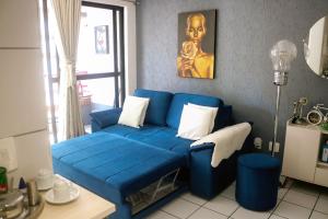 um sofá azul sentado numa sala de estar em Apartamento com Varanda vista mar, Max 4 Pessoas em Fortaleza mais 44 fotografias