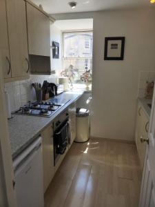 a kitchen with a stove and a counter top at Central Georgian Garden Flat with Free Parking in Bath