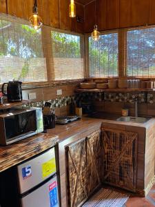 a kitchen with a refrigerator and a microwave at Cabañas Tierra Fértil #2 