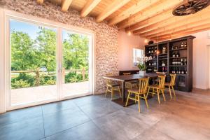 een eetkamer met een tafel en stoelen en een groot raam bij BORGO STALIS RESORT in Sesto al Reghena