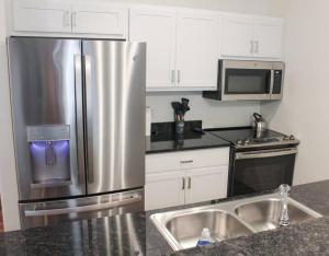 a kitchen with a stainless steel refrigerator and a microwave at Main Street Sun Prairie WI - 2 Bedroom in Sun Prairie