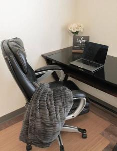 a black office chair with a desk with a laptop at Main Street Sun Prairie WI - 2 Bedroom in Sun Prairie