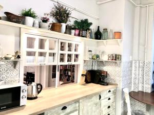 een keuken met witte kasten en een bar met planten bij Szentkirályi Art Studio in Boedapest