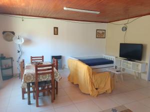 sala de estar con mesa y TV en Descanso Los Alamos en Plottier