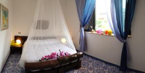 a bedroom with a bed with a mosquito net at B&B Il Resort Dell'Artista in Venetico