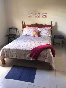 ein Schlafzimmer mit einem großen Bett mit rosa und violetten Decken in der Unterkunft Casa no Campo in Senhor do Bonfim
