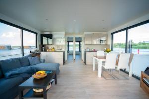 uma sala de estar com um sofá azul e uma cozinha em Hausboot the Hideaway LP25 em Klitten