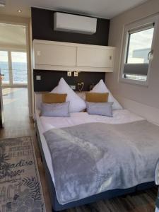 - une chambre dotée d'un grand lit avec des draps et des oreillers blancs dans l'établissement Hausboot Auszeit - LP11, à Laasow
