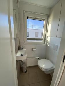 La salle de bains est pourvue de toilettes, d'un lavabo et d'une fenêtre. dans l'établissement Hausboot Auszeit - LP11, à Laasow
