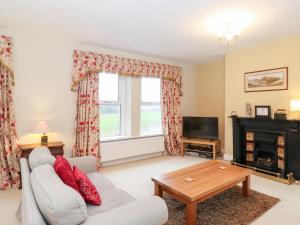 a living room with a couch and a fireplace at Hawthorne House in Cockermouth