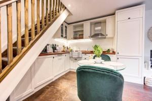 a kitchen with white cabinets and a green chair at 4 guests | Smart TV | Attractions in London