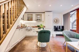 a kitchen with white cabinets and a green chair at 4 guests | Smart TV | Attractions in London