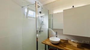 a bathroom with a white sink and a shower at Appartement Solane 2 LUMIO in Lumio +23 photos