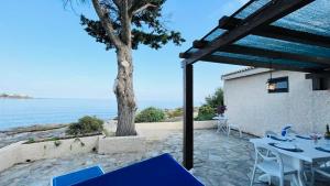 a patio with a table and chairs and the ocean at Appartement Solane 2 LUMIO in Lumio