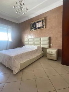 a bedroom with a bed and a chandelier at Appartement spacieux à seulement 10minutes de la plage d'Agadir in Agadir