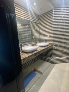 ein Badezimmer mit zwei weißen Waschbecken auf der Theke in der Unterkunft Appartement spacieux à seulement 10minutes de la plage d'Agadir in Agadir
