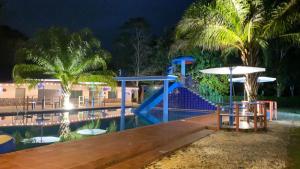 un complexe avec un toboggan et une piscine la nuit dans l'établissement Hacienda Alajuela, à Colón