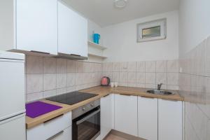 eine Küche mit weißen Schränken und einer Spüle in der Unterkunft XXL Apartment - Private Pool in Omiš