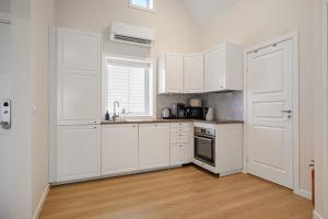 a white kitchen with white cabinets and a window at Unique and Spacious Apt close to City Centre in Stavanger