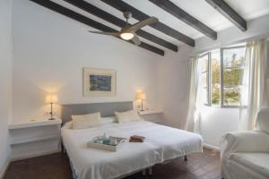 1 dormitorio con 1 cama blanca y ventilador de techo en Casa Morant On The Promenade Mhm en Cala Ratjada