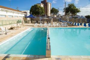 una gran piscina con tumbonas y sillas en SESC ARAXÁ, en Araxá