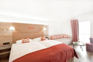 una camera d'albergo con un grande letto e un divano di Hotel Alpina Superior a Pettneu am Arlberg