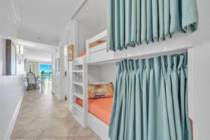 a bedroom with a bunk bed with blue curtains at Gulf Dunes 305 Coastal Dream in Fort Walton Beach +61 photos