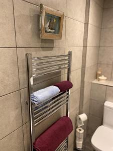 a towel rack in a bathroom with purple towels at No 10, St James Street, Burnley in Burnley