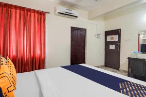 a bedroom with a bed and a red curtain at SPOT ON S.k Guest House in Calangute