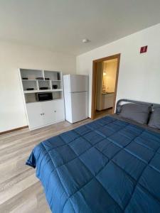um quarto com uma cama azul e um frigorífico em Unit 1 - Stand Rock Studios em Wisconsin Dells