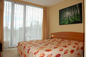 a bedroom with a bed and a large window at Hotel Balneolum Superior in Quedlinburg