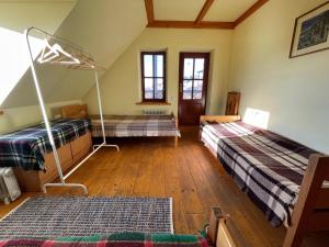 Habitación en el ático con 2 camas y suelo de madera. en Tisnyi 7 Guest House, en Kamianets-Podilskyi