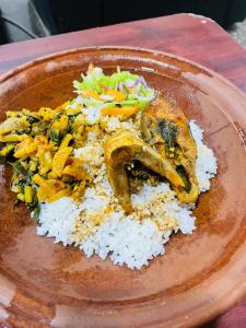 un plato de comida con arroz y verduras. en The Eco-Lodge 더 에코-롲지 en Maho