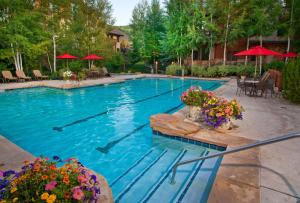 a swimming pool with flowers and umbrellas at Wildflower Place Unit 5 in Edwards