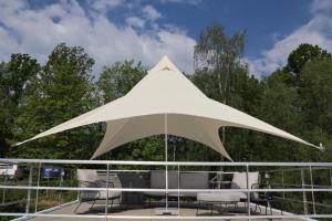 a large white umbrella on the deck of a boat at Hausboot CALIENE - LP9 in Höxter